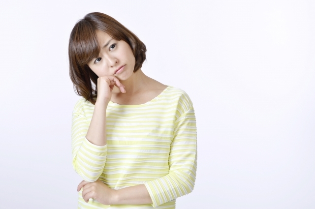 女性が首をかしげる 画像